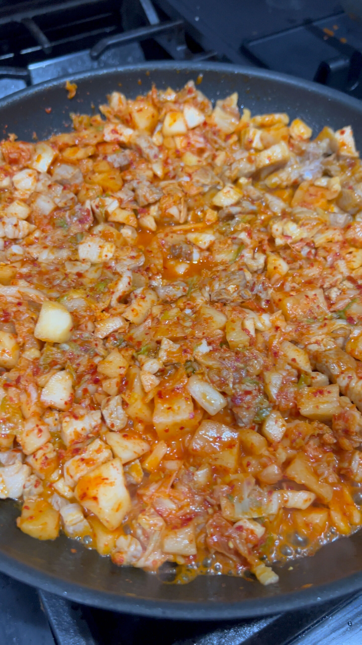 Sauteing the pork and kimchi together