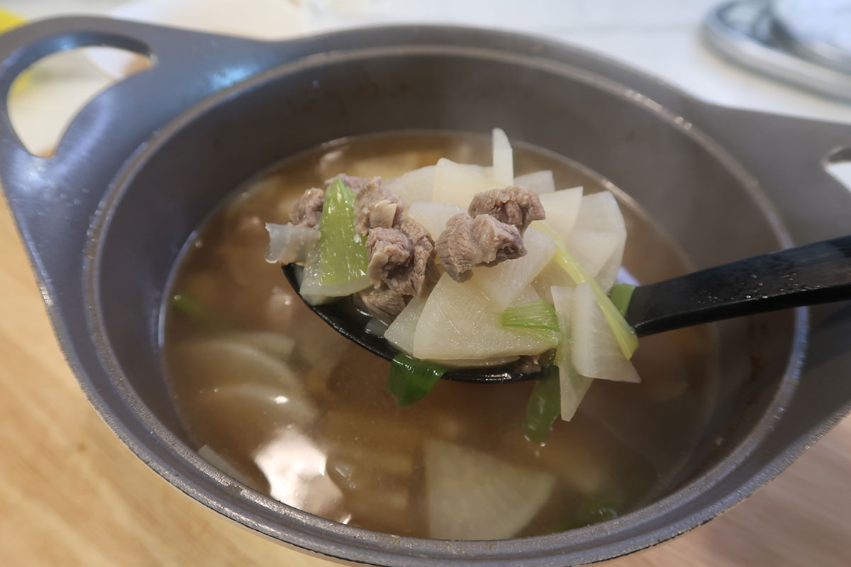 Beef and radish soup scooped in a ladle