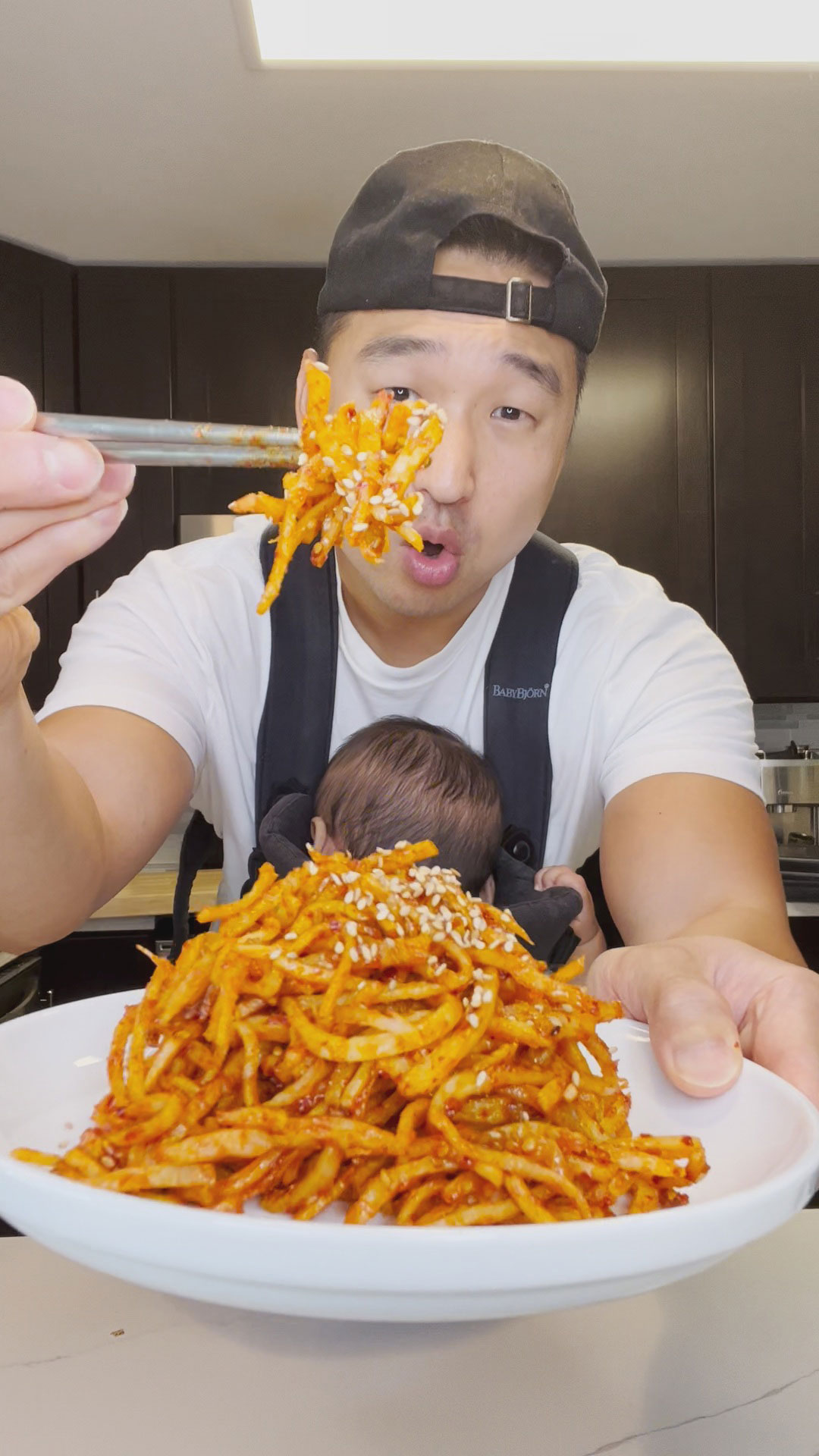 Chef Chris Cho holding a plate of spicy dried squid 