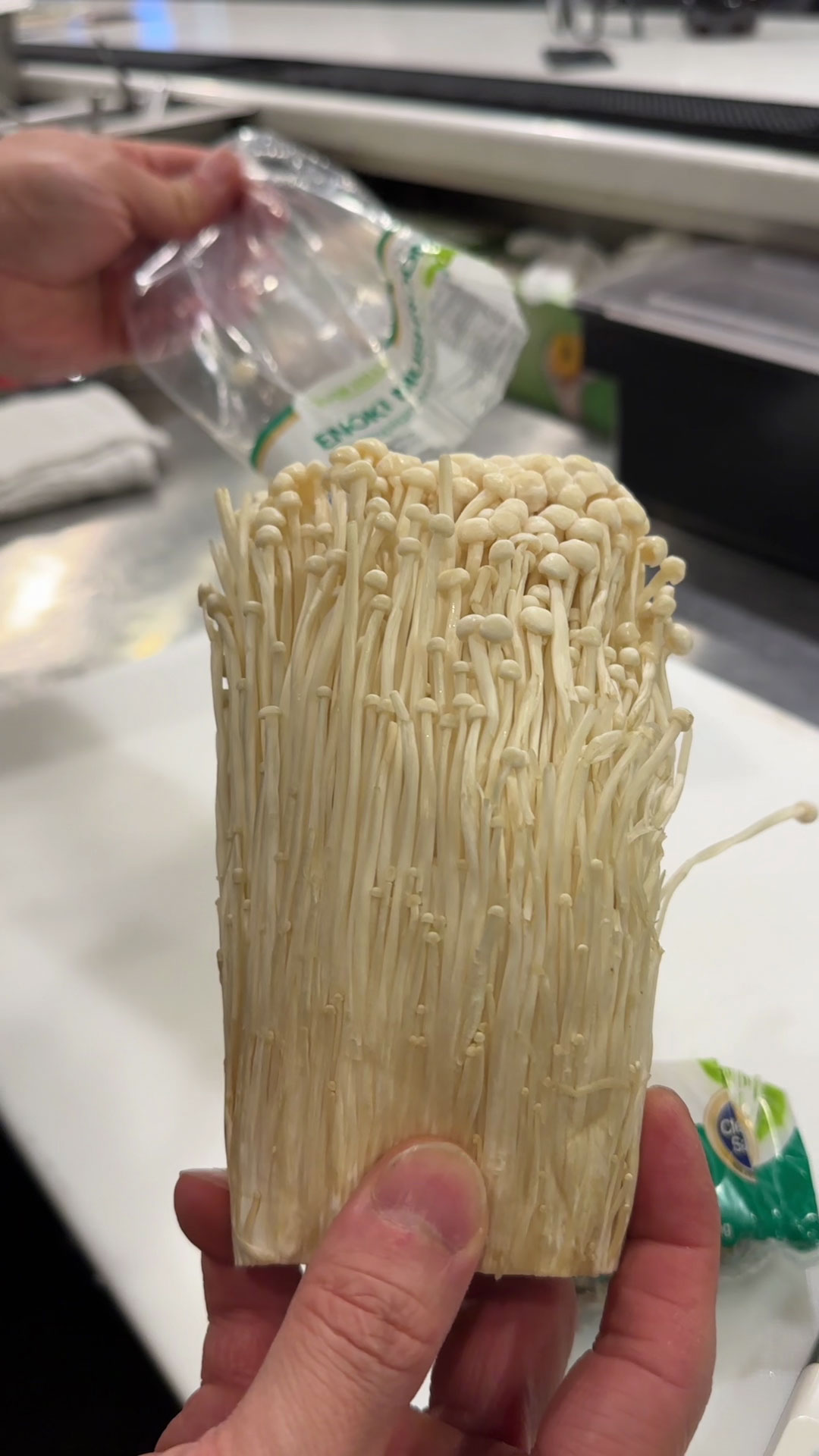 Slice off the bottom 1 inch of the enoki mushroom 