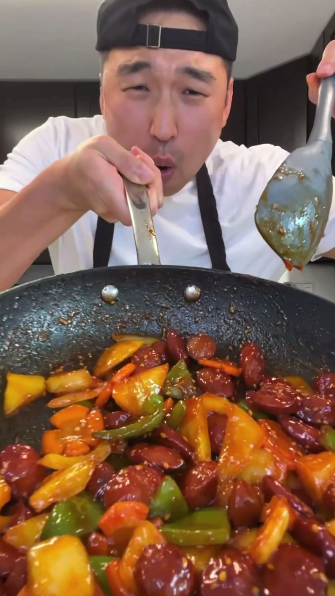 Chef Chris Cho holding a pan with Korean Sausage Stir fry 