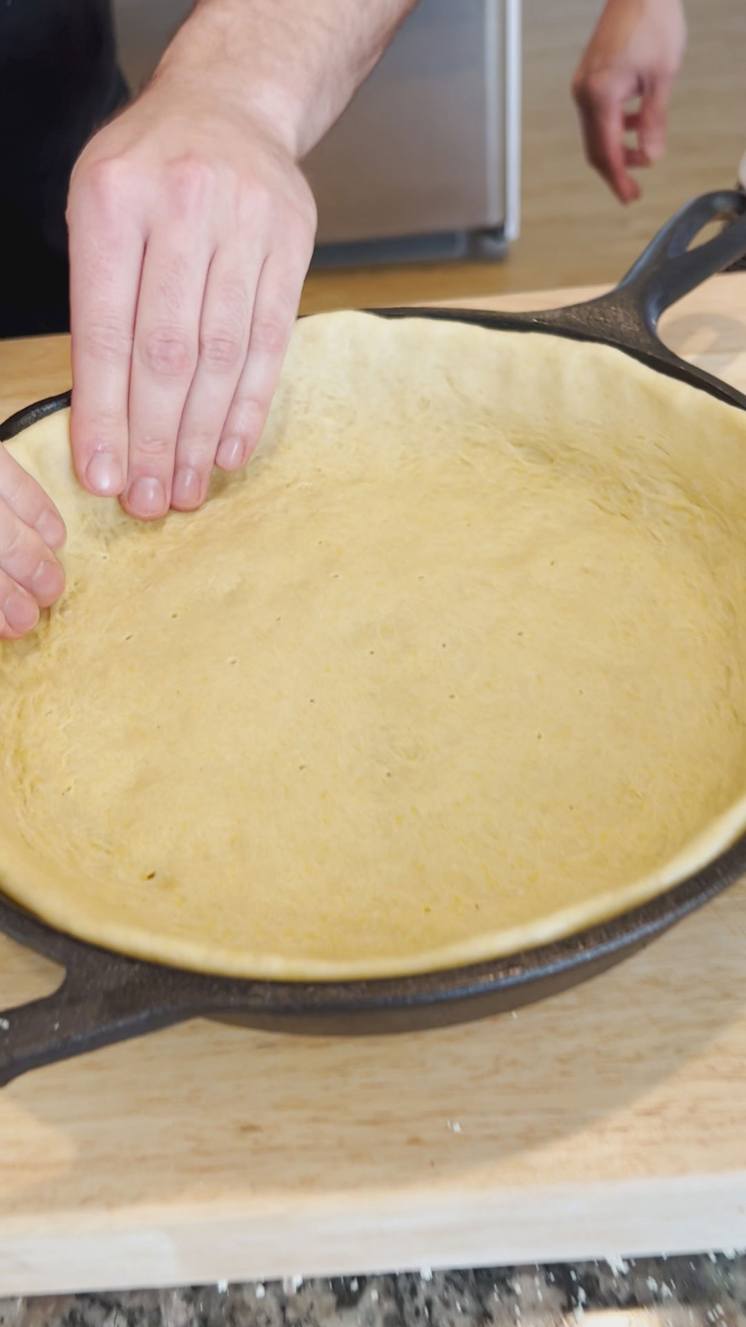 Deep dish pizza dough stretched to the circumference of the cast iron skillet 
