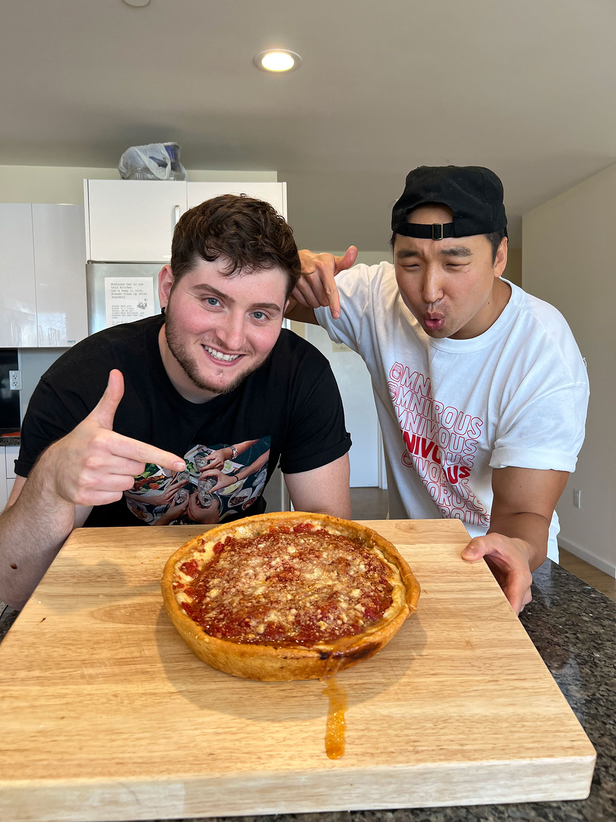 Omnivorous Adam and Chef Chris Cho holding a deep dish pizza