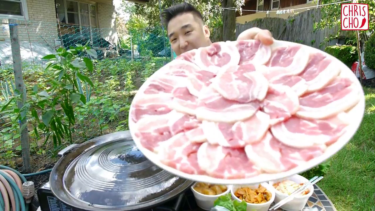 Chef Chris Cho holding a plate of samgyeopsal