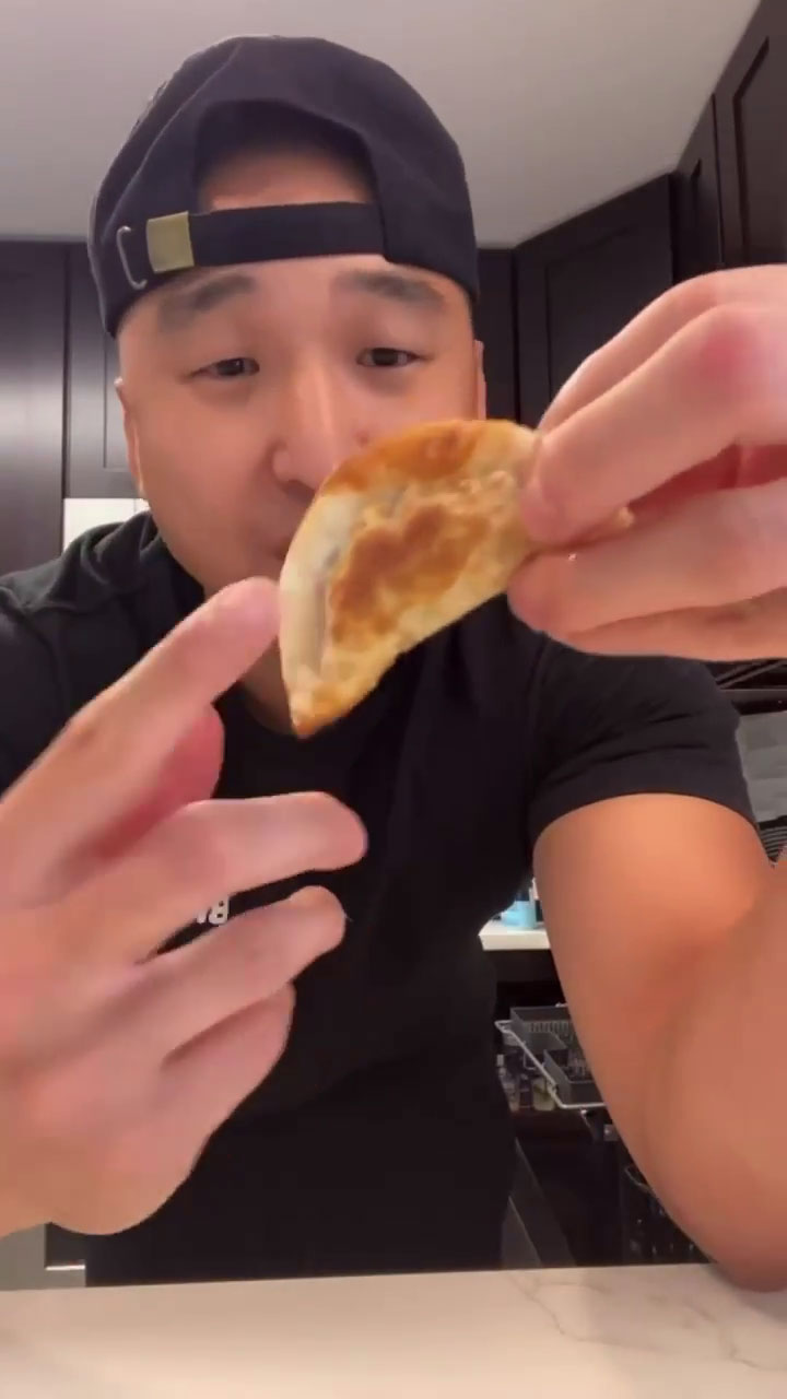 Chef Chris Cho holding a piece of mandu 
