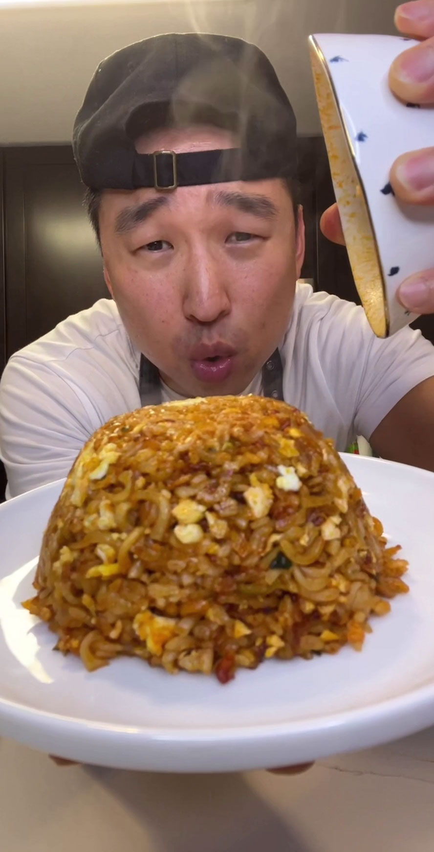 Chef Chris Cho holding a plate of spicy ramen fried rice 