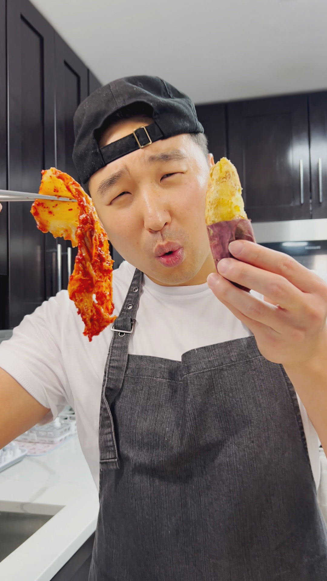 Chef Chris Cho holding Korean sweet potato and kimchi