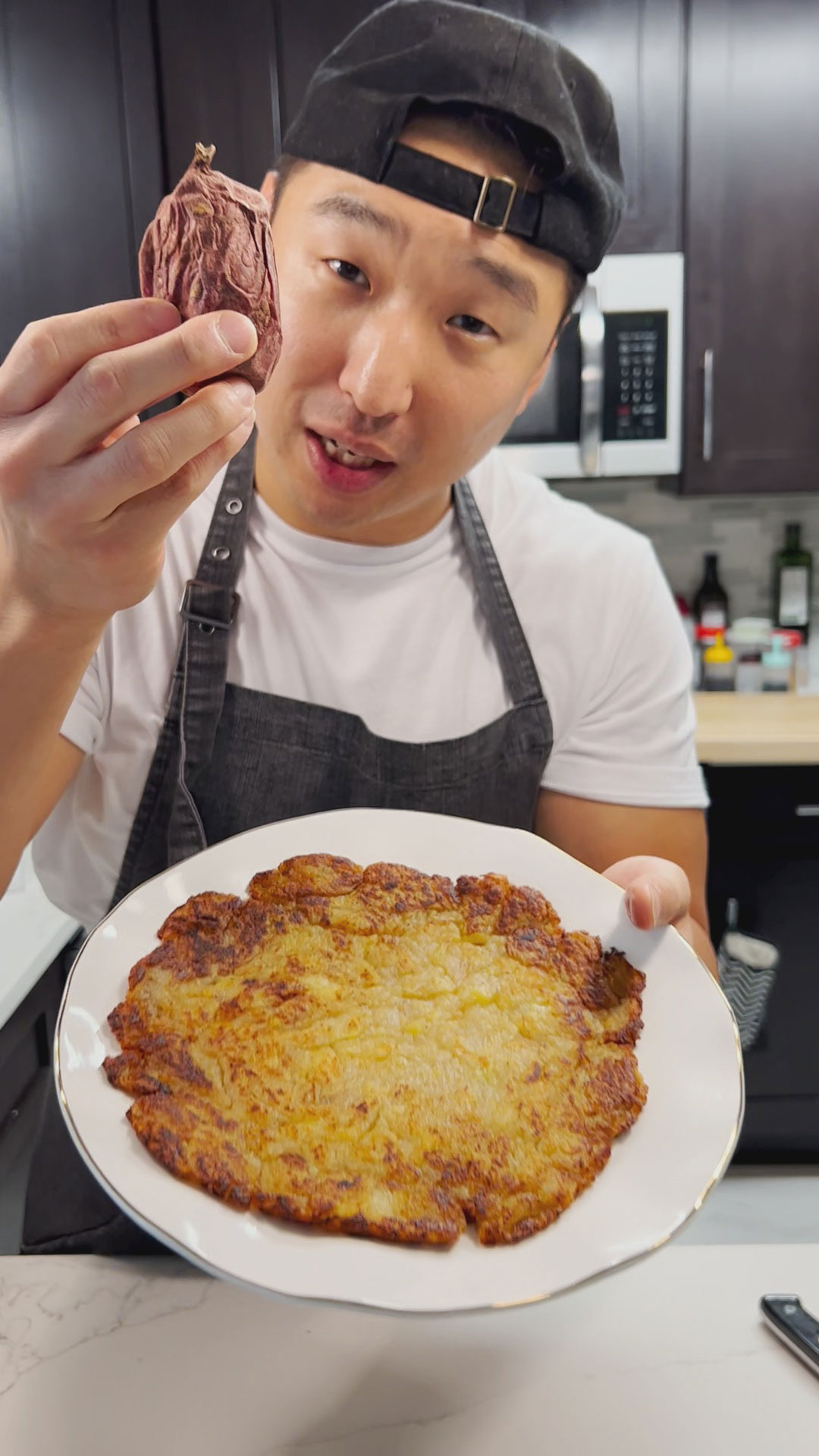 Chef Chris Cho holding the plate of Korean Sweet Potato Pancake 