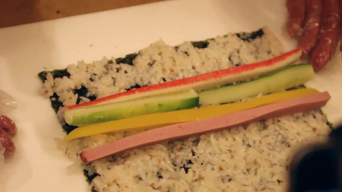 Lining up vegetables properly on top of the kimbap rice 