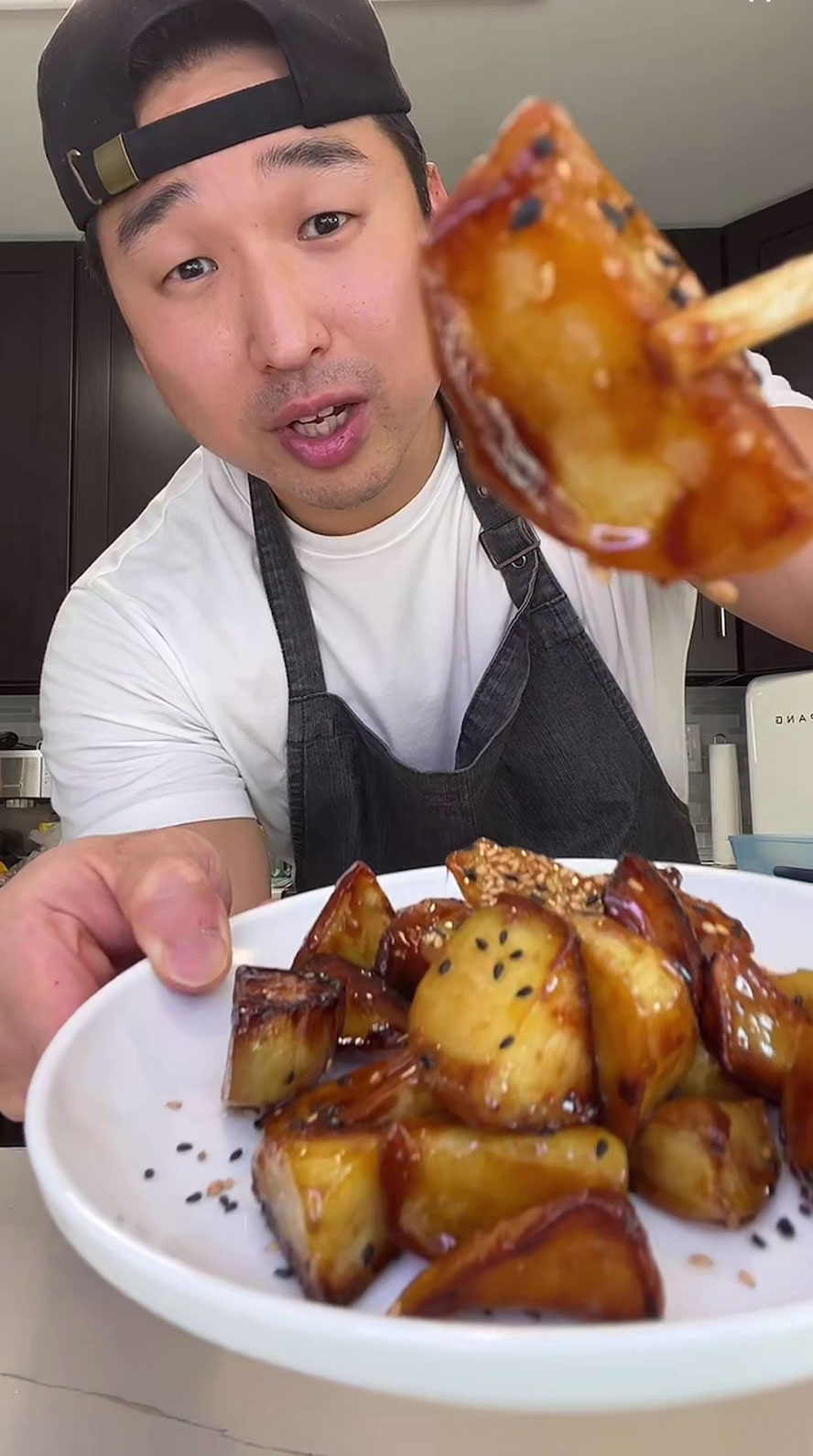 Chef Chris Cho holding a plate of Korean candied sweet potatoes 