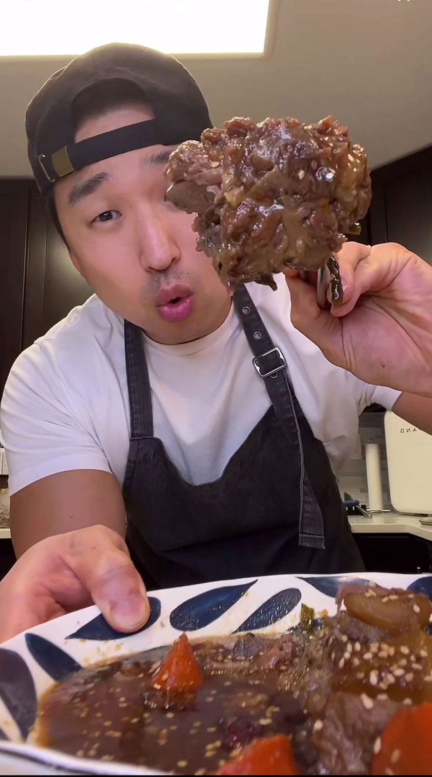 Chef Chris Cho holding a plate of Korean Braised Oxtail 