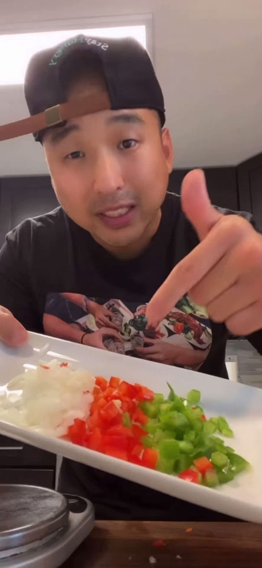 Chef Chris Cho holding a plate of diced vegetables 