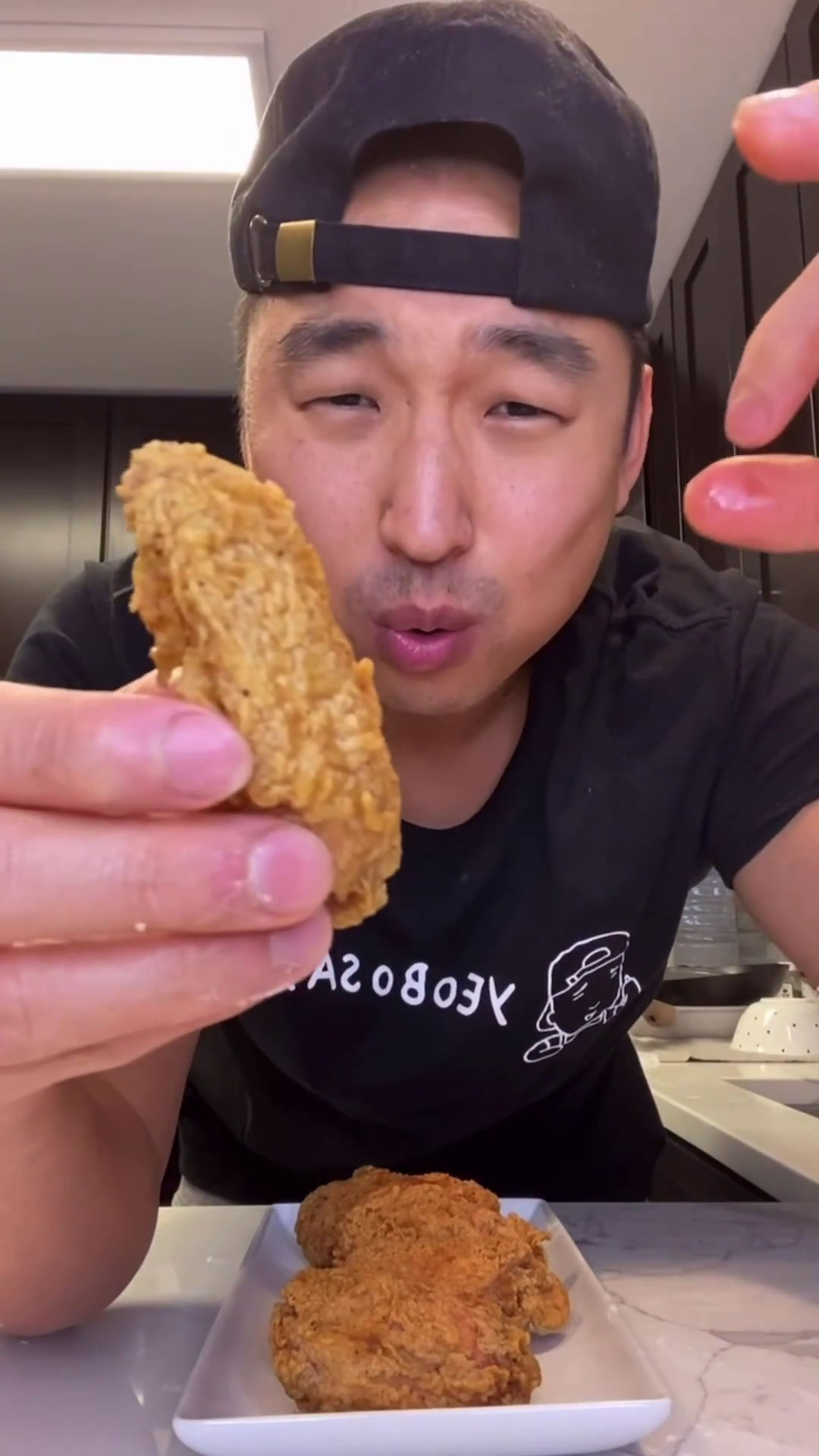 Chef Chris Cho holding fried chicken wings 
