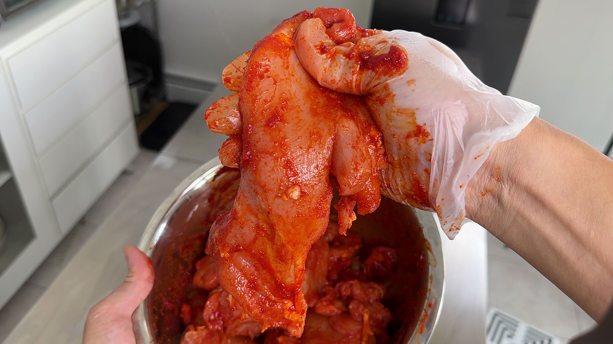 Coating chicken with spicy BBQ sauce 