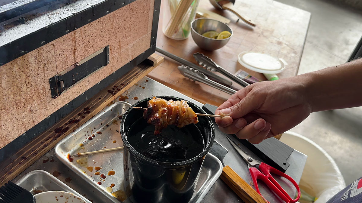 Dipping the yakitori in tare