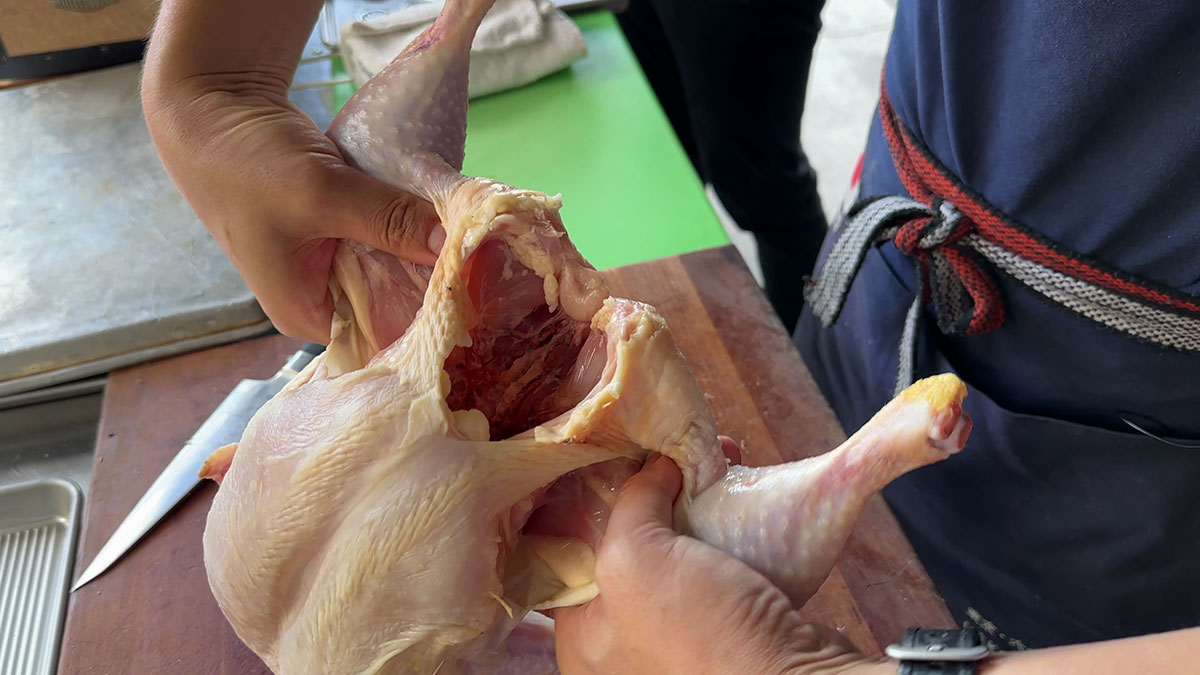 Breaking the joints to remove the leg and thigh from the chicken
