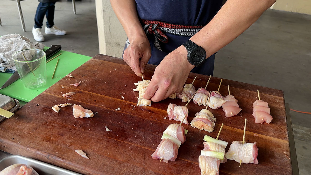 Weaving the chicken skin in the skewer