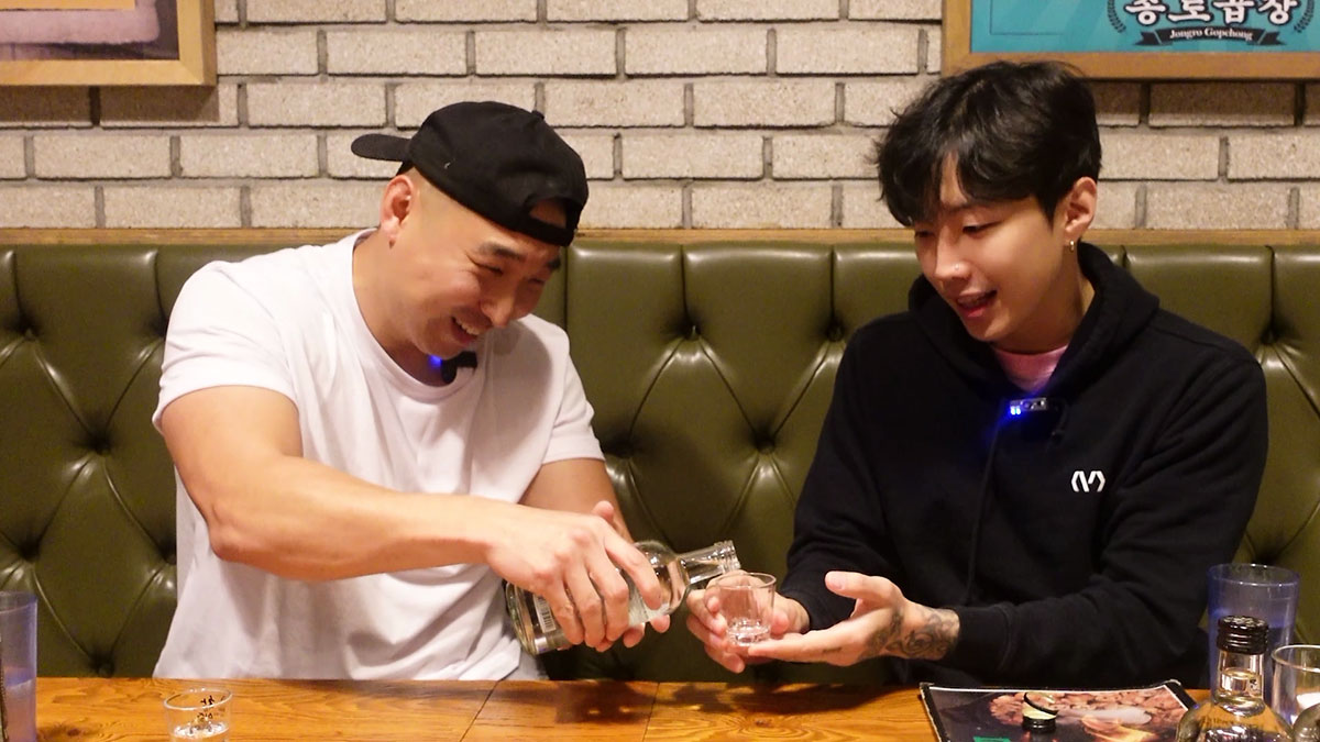Chef Chris Cho pouring and Jay Park receiving a drink