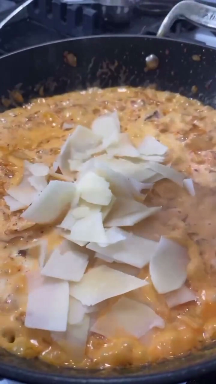 Adding parmesan cheese to kimchi pasta sauce 