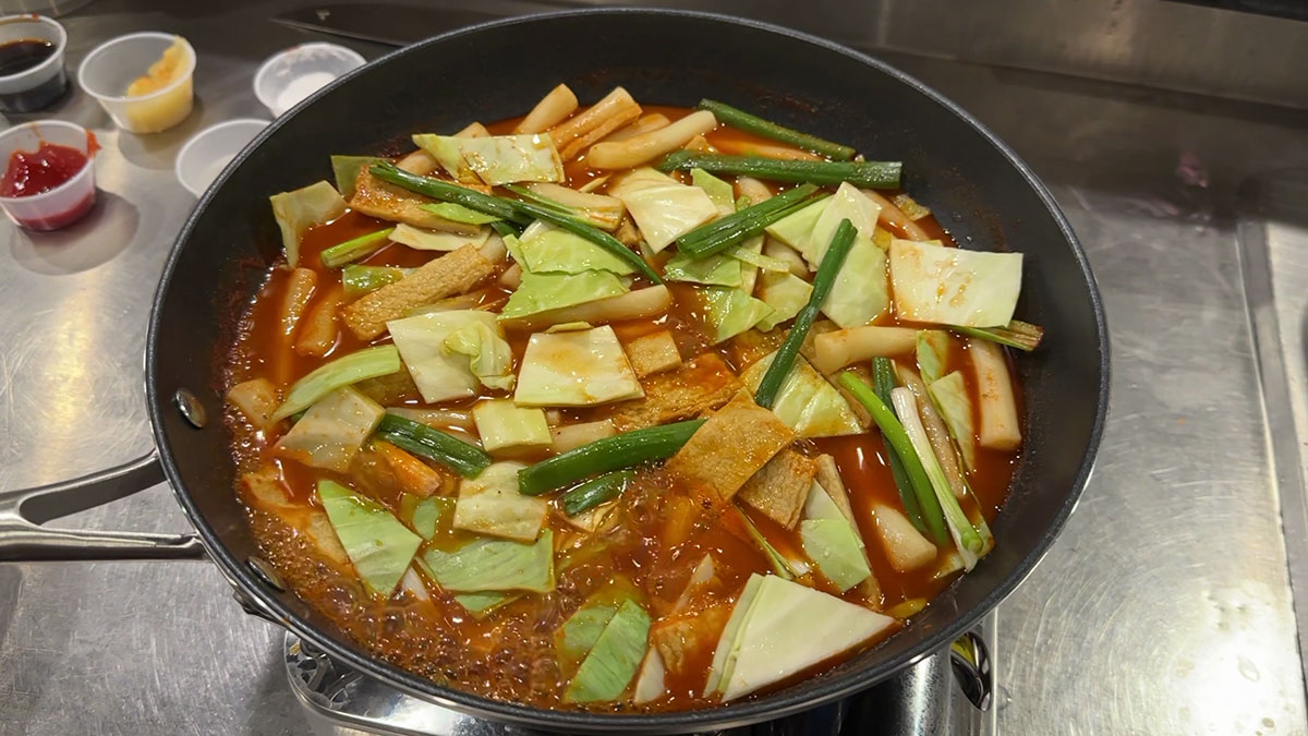 Boil the rice cake, fish cake, cabbage, and scallions in the sauce 