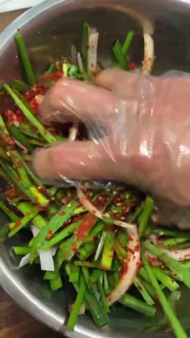 Mix the seasoned chives with your gloved hand 