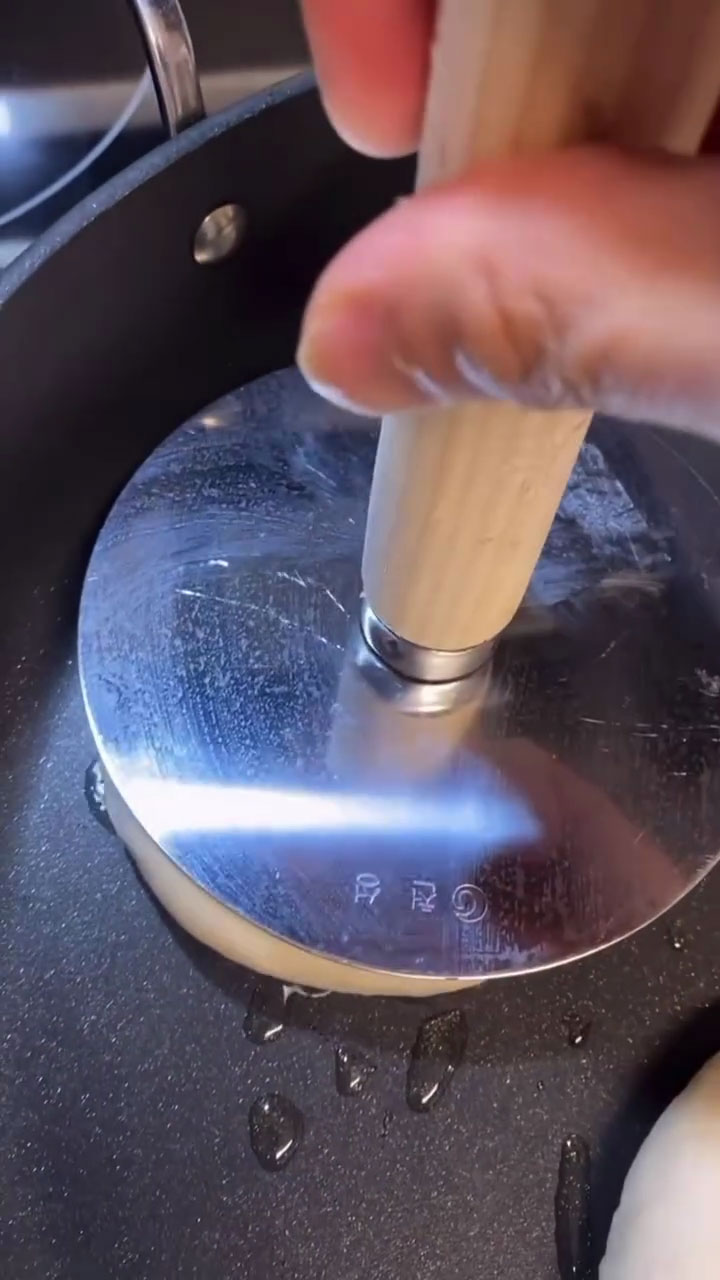 Press down the dough with a hotteok press