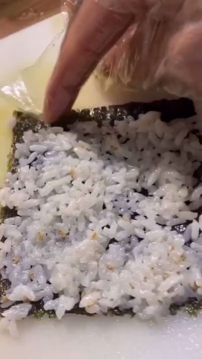 Spread a small handful of rice on the seaweed