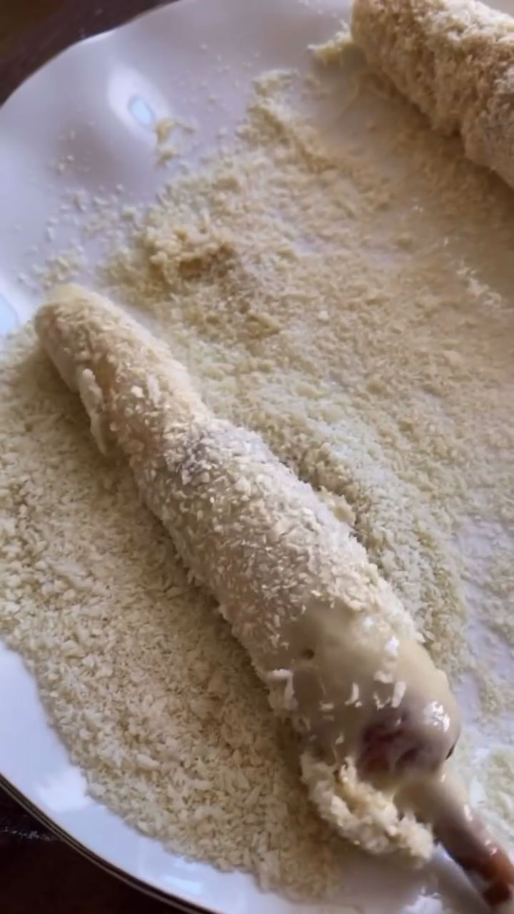 Coat doughed corndog with breadcrumbs 