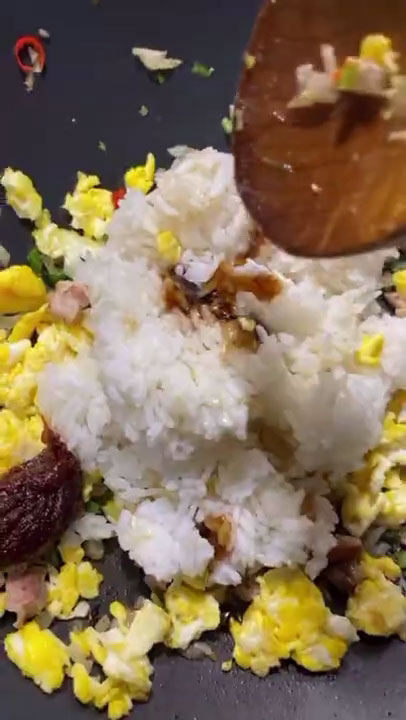 Adding and seasoning the eggs and rice on the sauteed chicken and aromatics