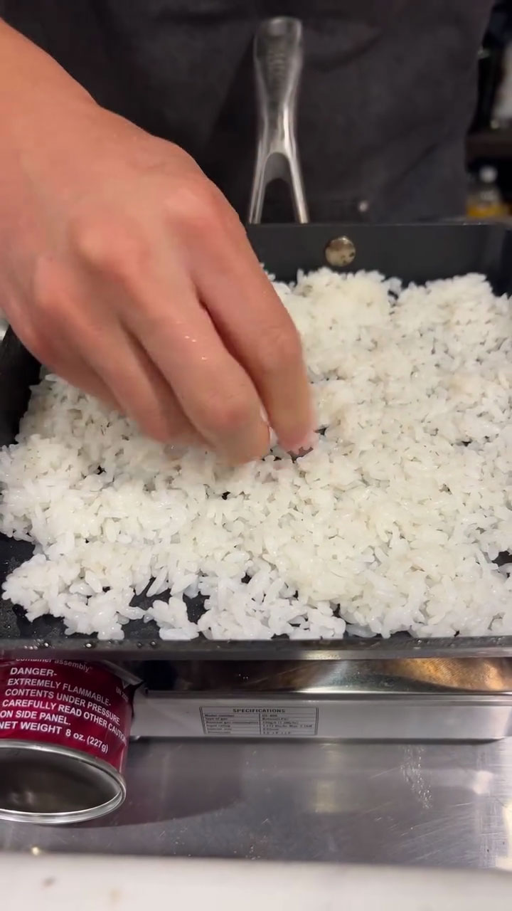 Spread the rice out evenly to the hot pan