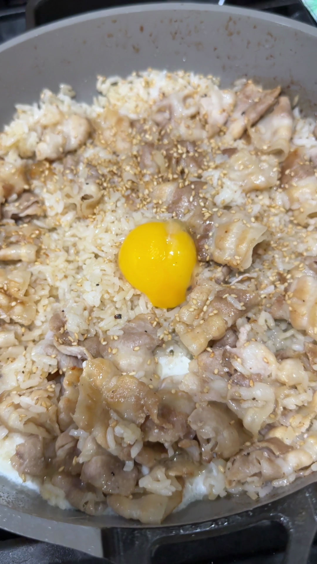 Garnish the pork belly fried rice with sesame seeds and egg yolk 