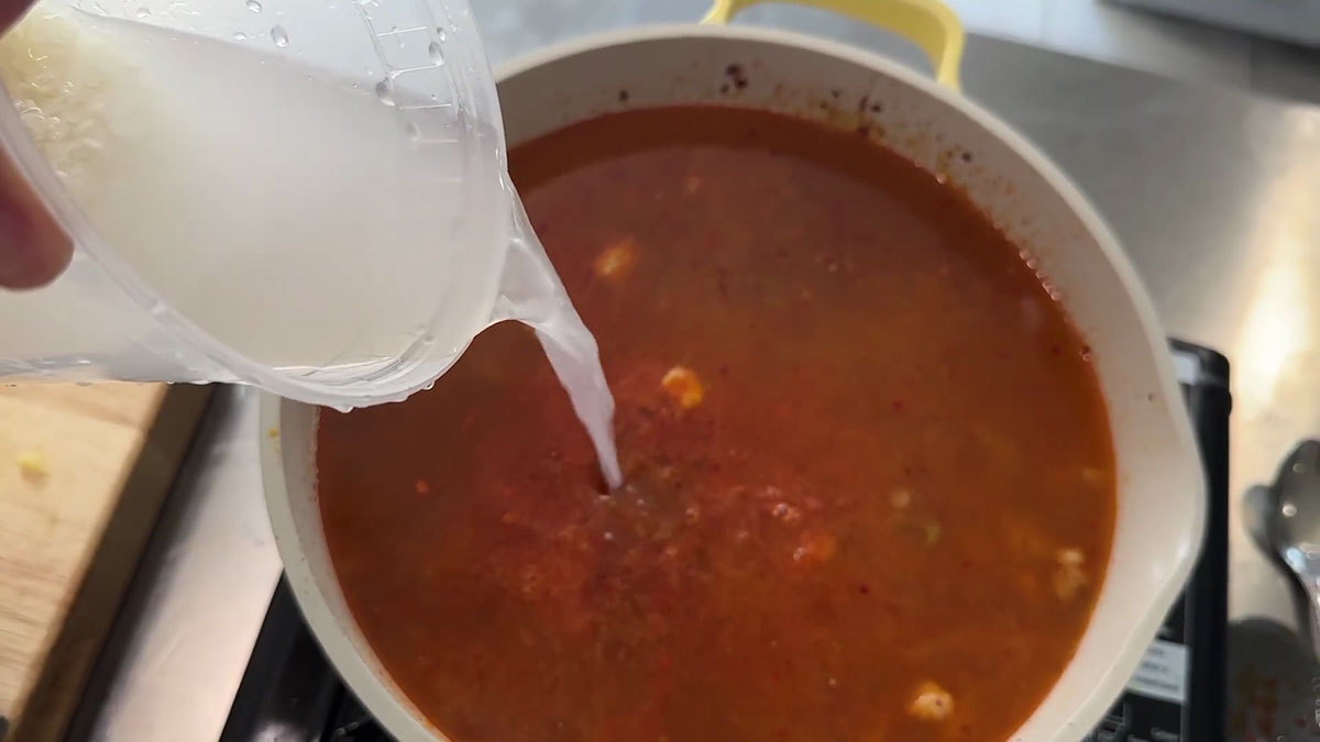 Add rice water to the sauteed pork 