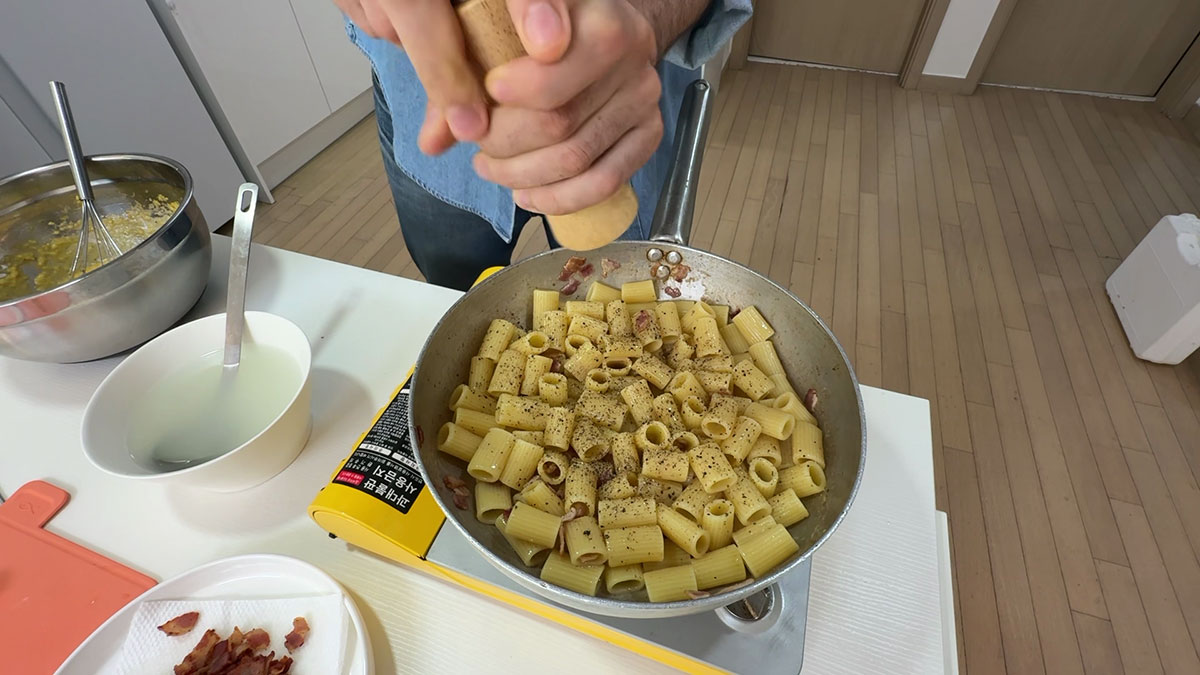 Tossing the pasta in bacon fat