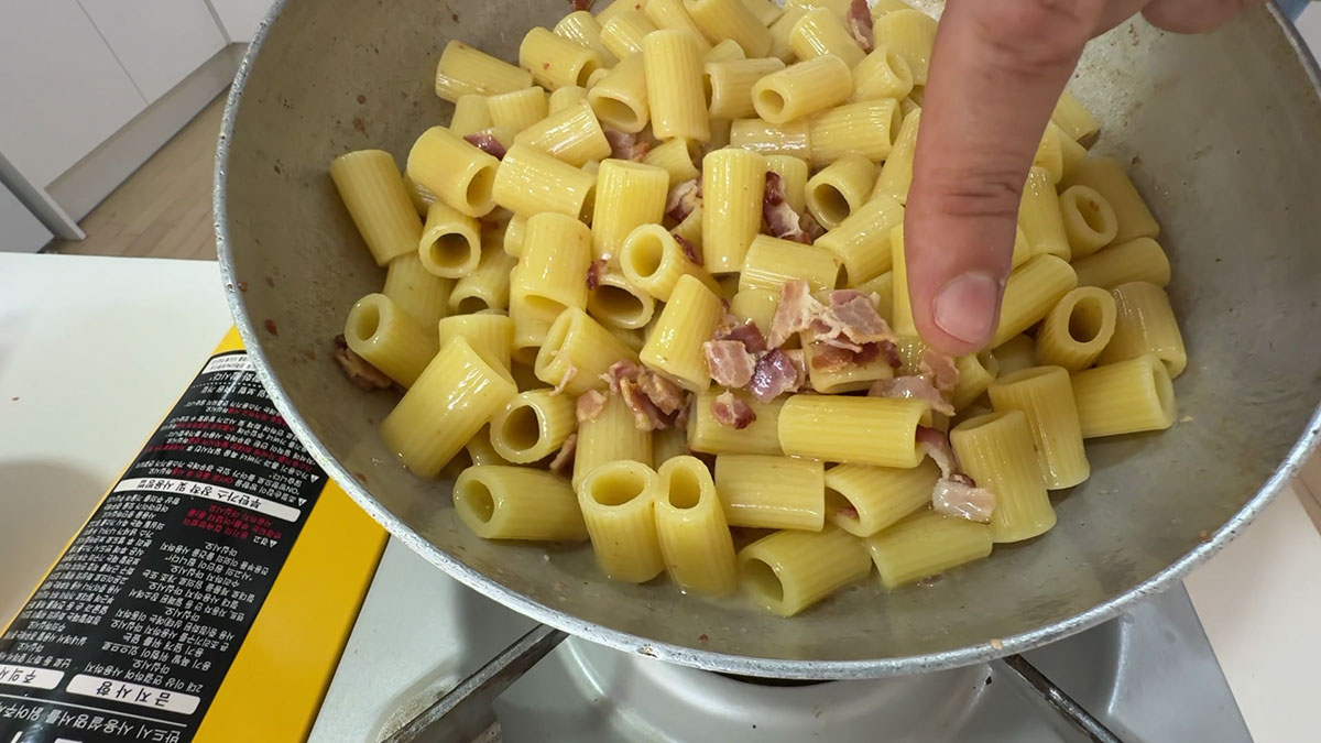 Tossing the pasta in bacon fat