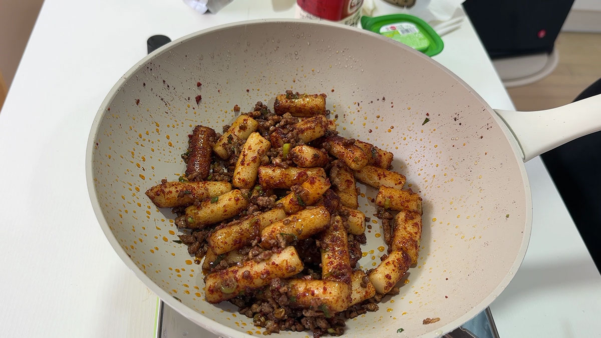 Add gochugaru to the stir fried tteokbokki 