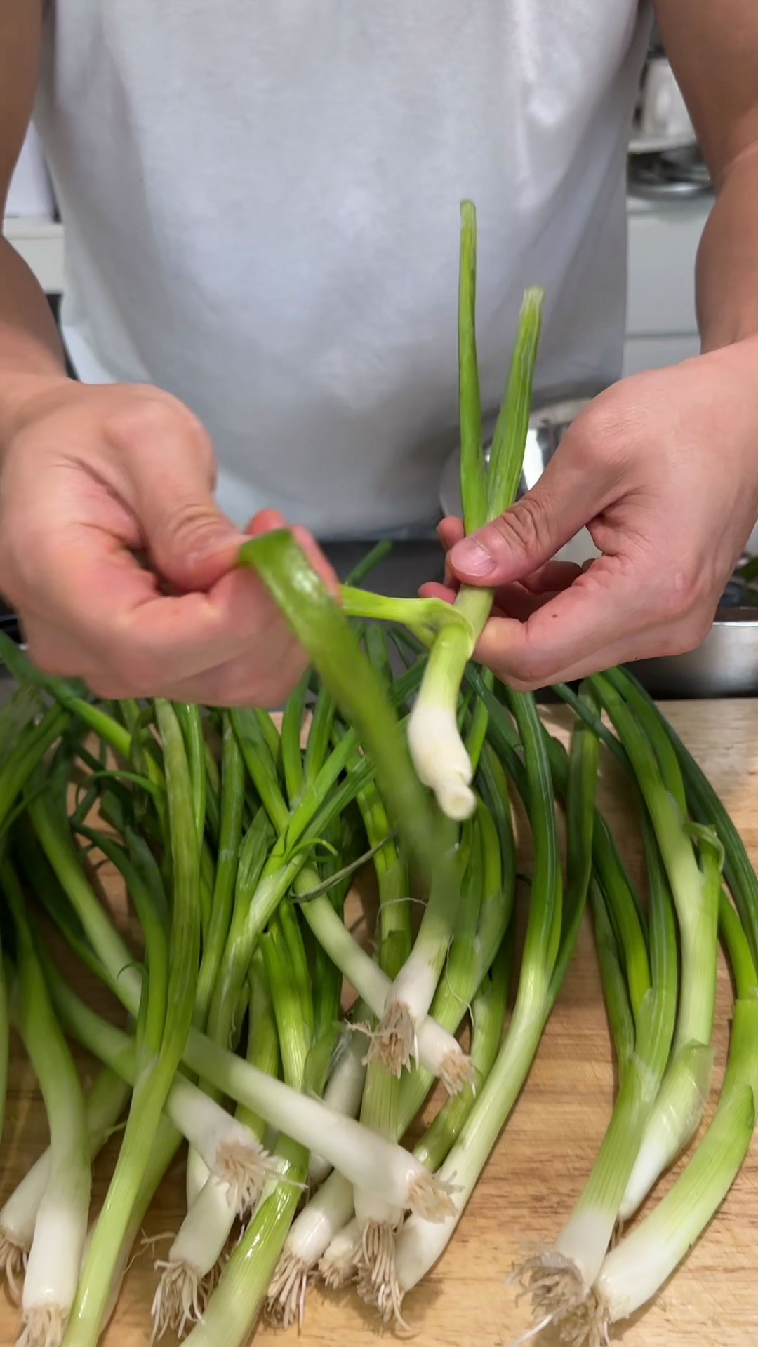 Peeling off wilted scallion leaves 