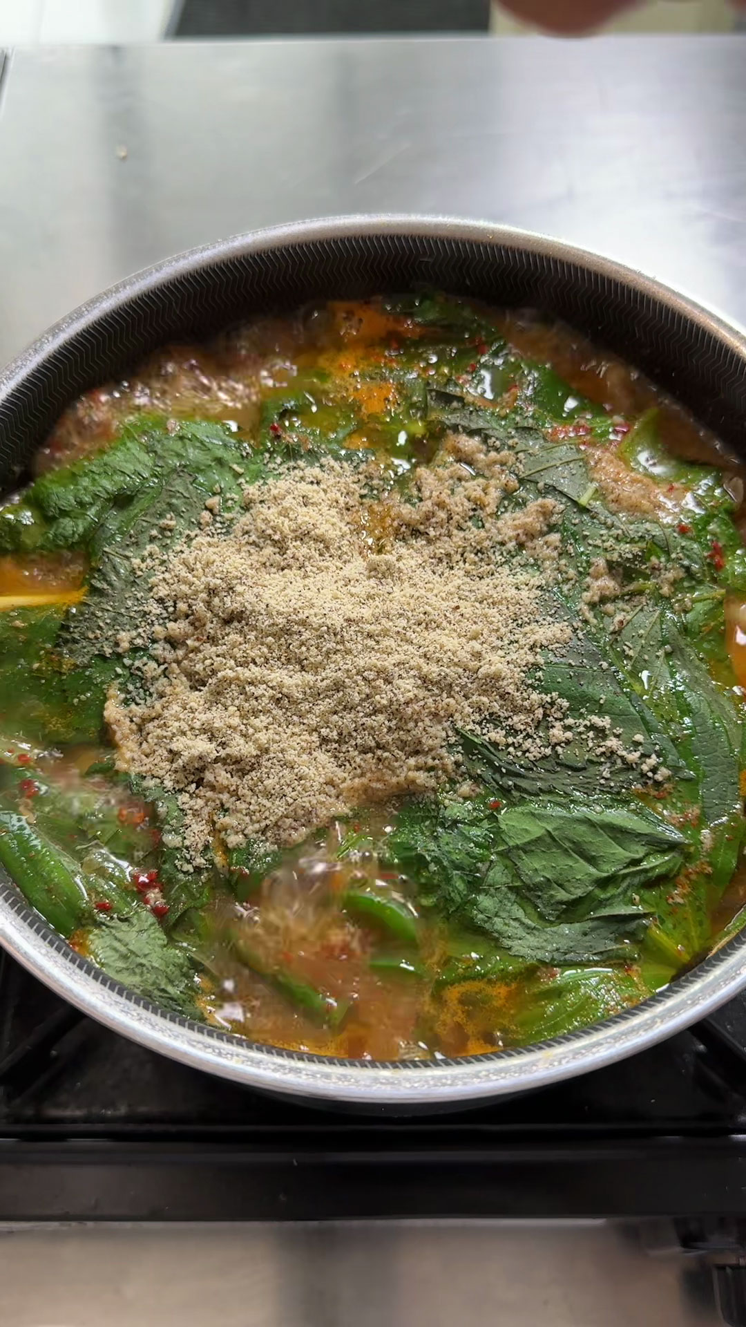 Added the scallions, perilla leaves, and perilla leaf powder into the gamja tang