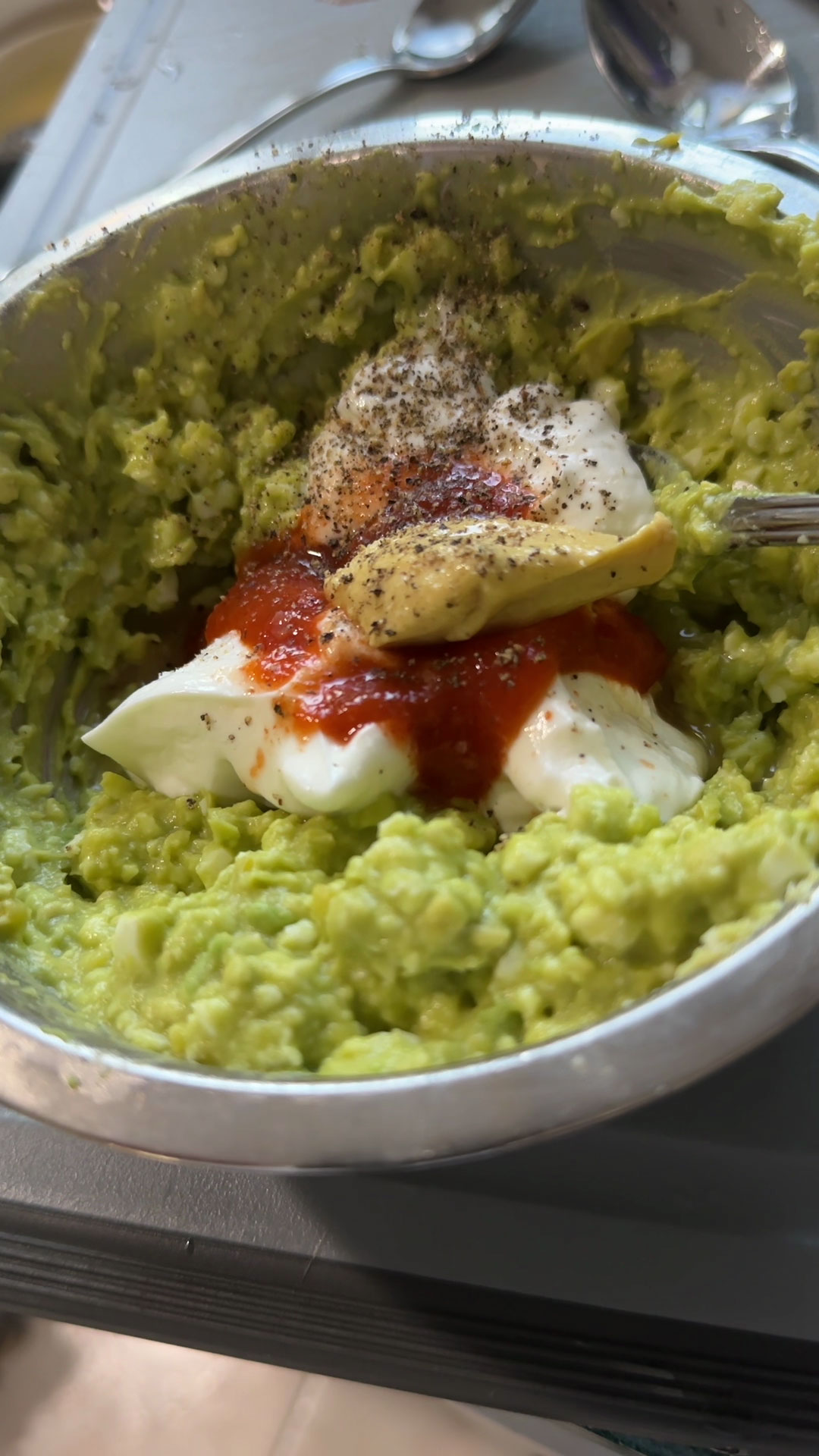 Combine egg, avocados, greek yogurt, mustard, lemon juice, chili sauce, salt, and pepper 