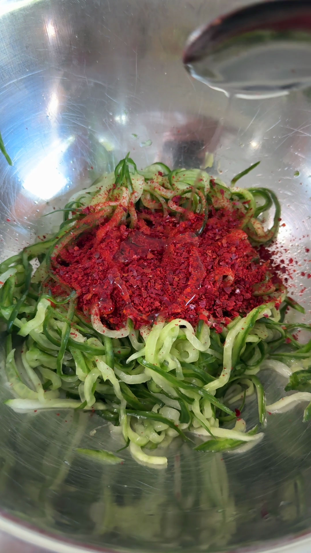 Season the cucumber with fish sauce, vinegar, gochujang, gochugaru, allulose, sesame oil, and garlic 